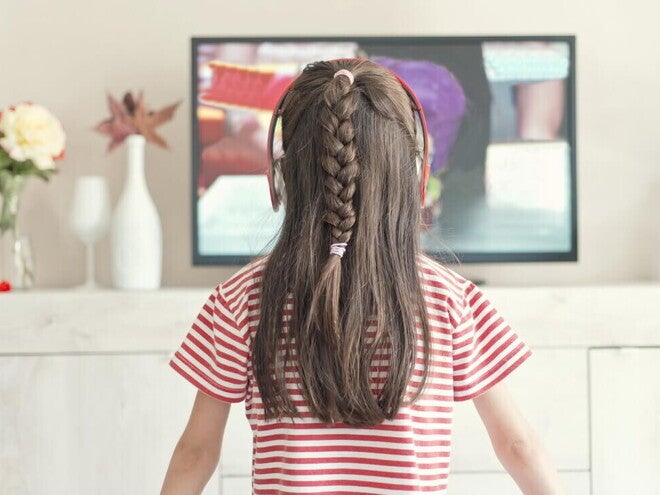 Niña pequeña viendo la televisión.