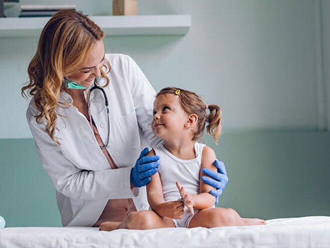 Conoce qué es la escarlatina Doctora revisando al bebé con escarlatina