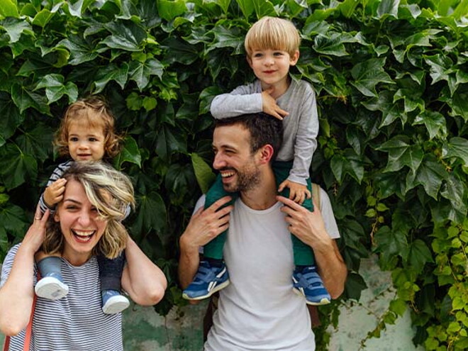 Estilos de crianza para educar a mi hijo Los padres riendo con los hijos alzados