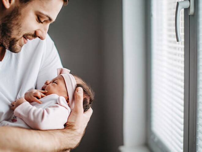 Los granitos en la cara de los bebés es un fenómeno común Papá alzando su bebé y revisando los granitos de su cara
