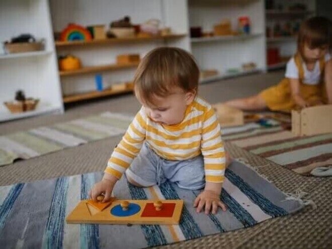 Actividad Montessori para bebés de 8 a 12 meses utilizando un rompecabezas de formas para estimular la coordinación, la exploración y la autonomía.
