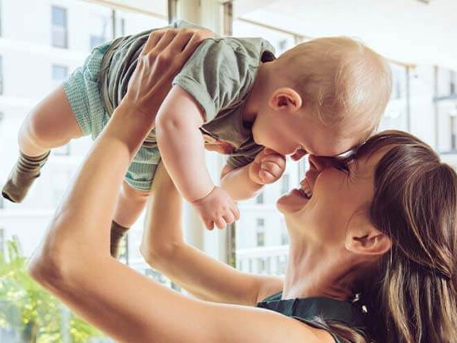Conoce que es la curva de crecimiento y desarrollo. Mamá cargando a su bebé.