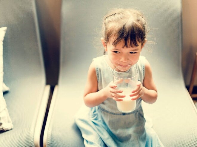 Niña tomando leche Niña tomando leche para tener defensas fuertes