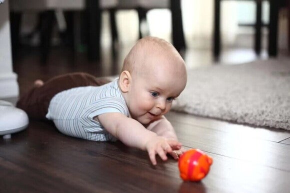 Tummy Time Bebé acostado sobre su pancita en el piso, haciendo tummy time.