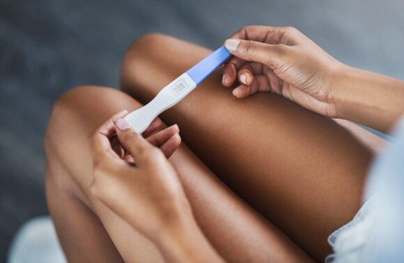 Mujer con prueba de embarazo Mujer sosteniendo prueba de embarazo