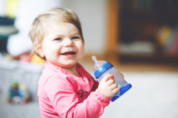 Niño bebiendo leche Niña sentada tomando un vaso de leche