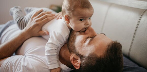 Los juegos son fundamentales para los bebés de cuatro meses Papá cargando a su bebé de cuatro meses