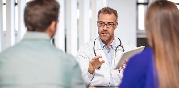 Existen diversas ayudas médicas para facilitar la dilatación. Padres revisando con el médico las ayudas médicas para la dilatación.