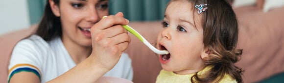 Mamá alimentando a su hija Mamá alimentando a su hija