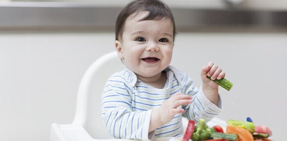Enseña a tu bebé de 9 meses a comer alimentos sólidos Bebé de 9 meses cogiendo alimentos sólidos