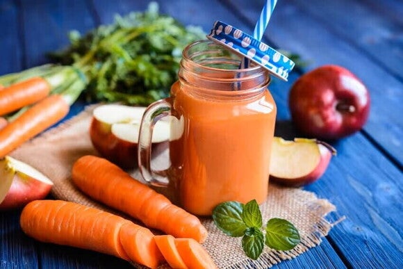 Jugo de naranja con frutas alrededor para prevenir resfriados
