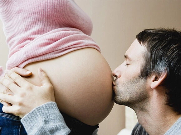 Presencia del padre en estudios prenatales hombre besando la panza de su esposa