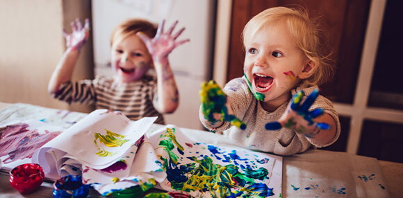 Conoce la importancia de la curva de crecimiento y desarrollo Niños pintando con pintura y riendo.