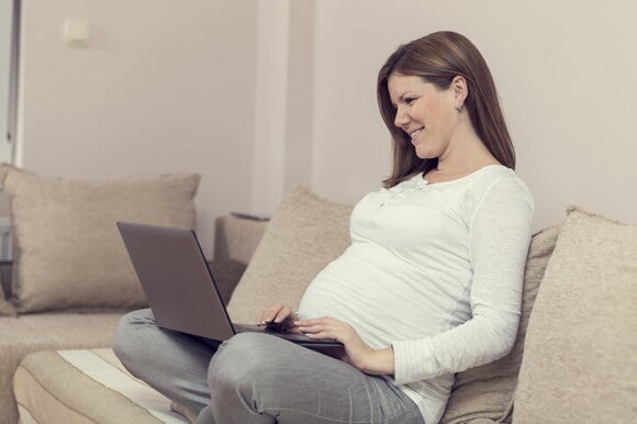 Sobrevivir al embarazo con un hijo pequeño Mamá utilizando el computador