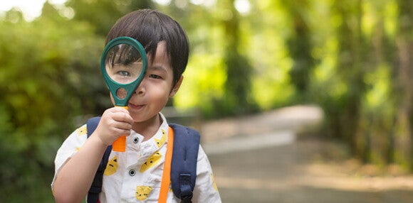 Existen varios tipos de estilos de aprendizaje. Niño con una lupa en la mano.